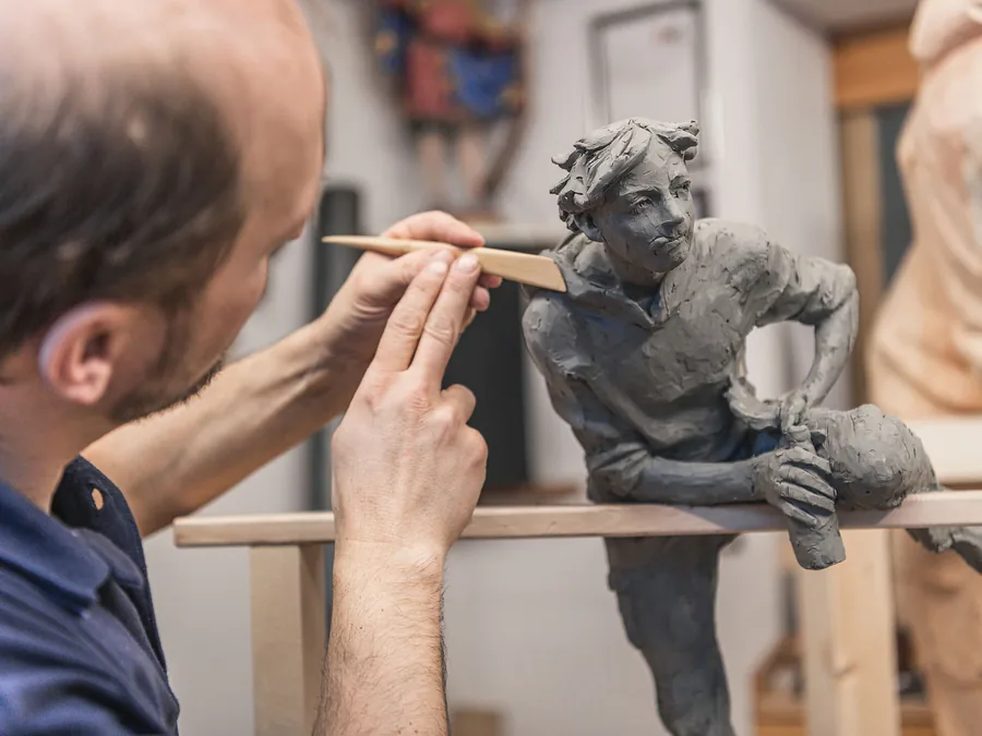 Bildhauer modelliert Tonfigur — Holz