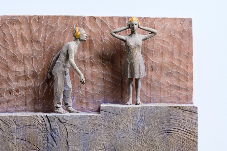Figurenpaar mit Kopfhörern an Mauer — Relief, Holz, gefasst mit Blattgold